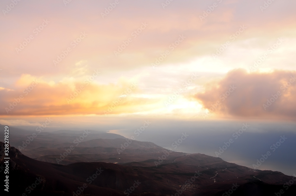 View from the top of the mountains in the early morning on the sea and mountains in a foggy haze. A stunning view from above in the early morning.
