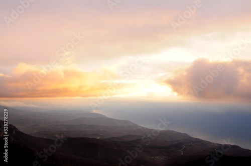 View from the top of the mountains in the early morning on the sea and mountains in a foggy haze. A stunning view from above in the early morning.