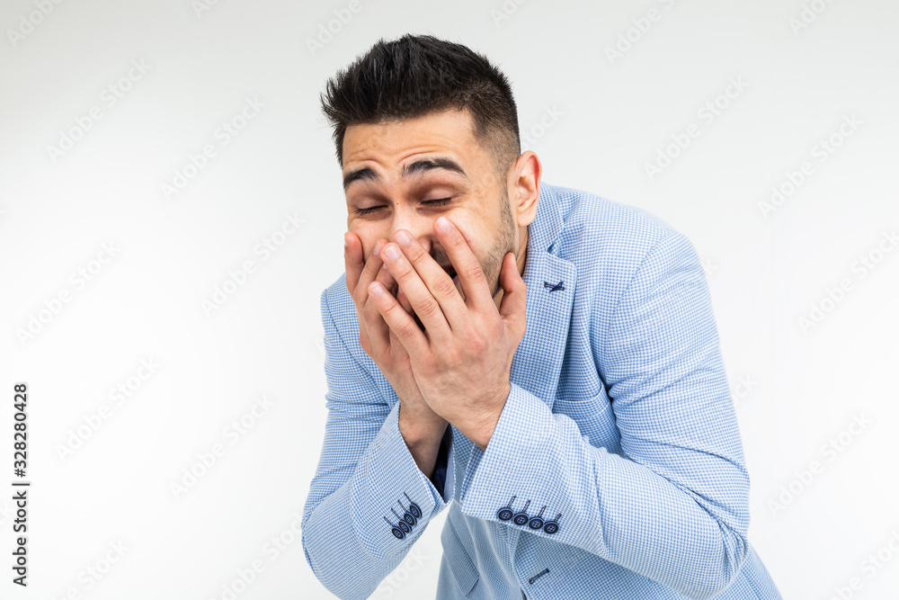handsome man in classic style laughs covering his mouth with his hand on a white background isolated handsome man in classic style laughs covering his mouth with his hand on a white background isolated
