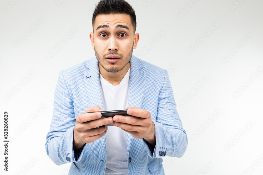 portrait of a brunet businessman in a stylish jacket watching video on a smartphone on a white background portrait of a brunet businessman in a stylish jacket watching video on a smartphone on a white background