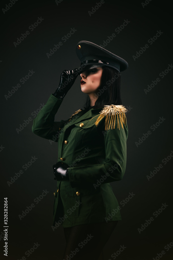 Portrait of a young woman in uniform, holding her cap by the hand Portrait of a young woman in uniform, holding her cap by the hand