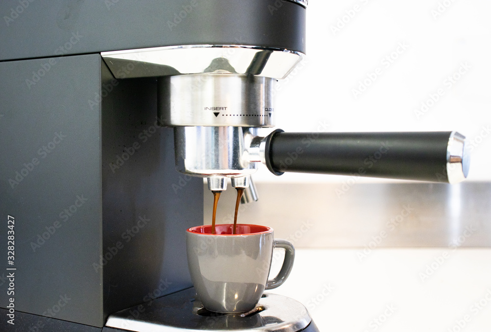 Coffee maker pouring fresh espresso coffee in a cup Coffee maker pouring fresh espresso coffee in a cup
