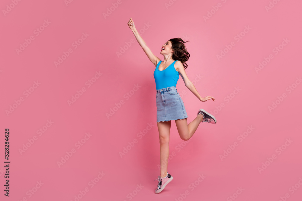 Full length profile photo of pretty funny crazy lady jump high up with imaginary umbrella wear blue tank-top denim short skirt shiny footwear isolated pink color background Full length profile photo of pretty funny crazy lady jump high up with imaginary umbrella wear blue tank-top denim short skirt shiny footwear isolated pink color background