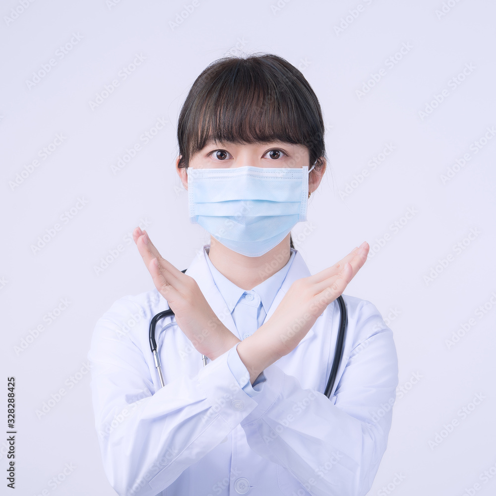 Young female doctor woman wearing mask, making stop sign gesture, saying No isolated on white background, refusing virus disease, close up, blank. Young female doctor woman wearing mask, making stop sign gesture, saying No isolated on white background, refusing virus disease, close up, blank.