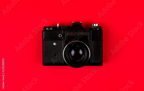 Flat lay film camera isolated on red background. Copy space