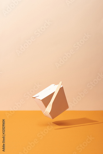 Arranged Organic box with fork on orange background with shadow