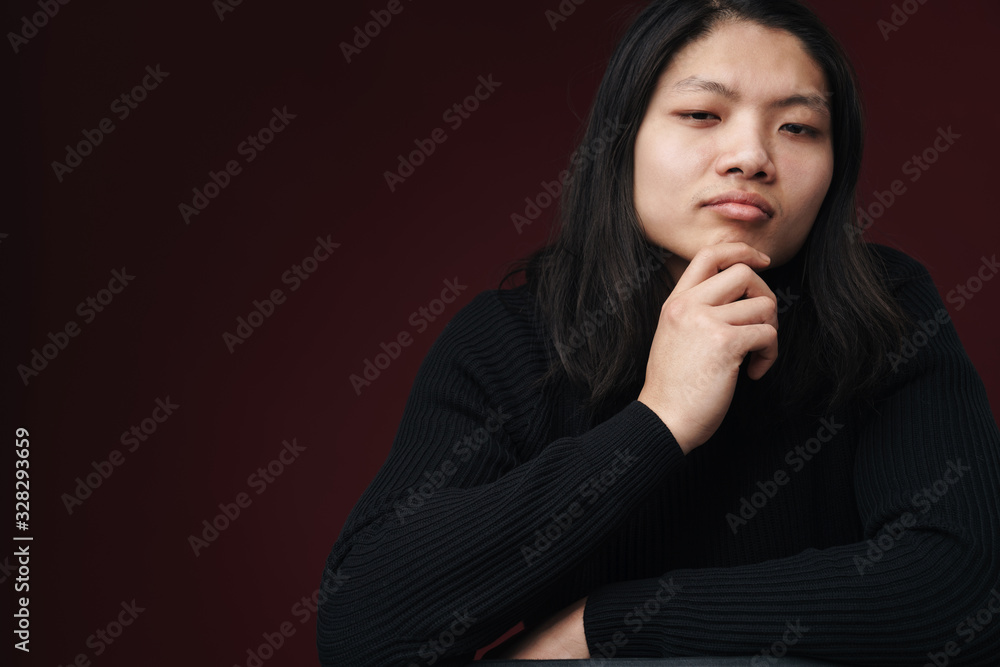 Image of thinking asian man posing and looking at camera Image of thinking asian man posing and looking at camera