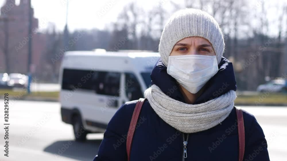 girl stands in a medical mask in a public place girl stands in a medical mask in a public place