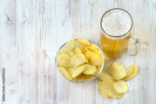 glass of beer and chips on a light background