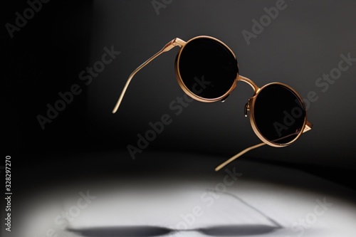 sunglasses levitate on a dark background, play of light photo