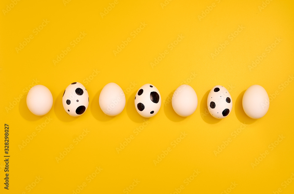 Many White eggs with green myrtle leaves pattern on yellow color background. Spring and Easter holiday concept with copy space. Many White eggs with green myrtle leaves pattern on yellow color background. Spring and Easter holiday concept with copy space.