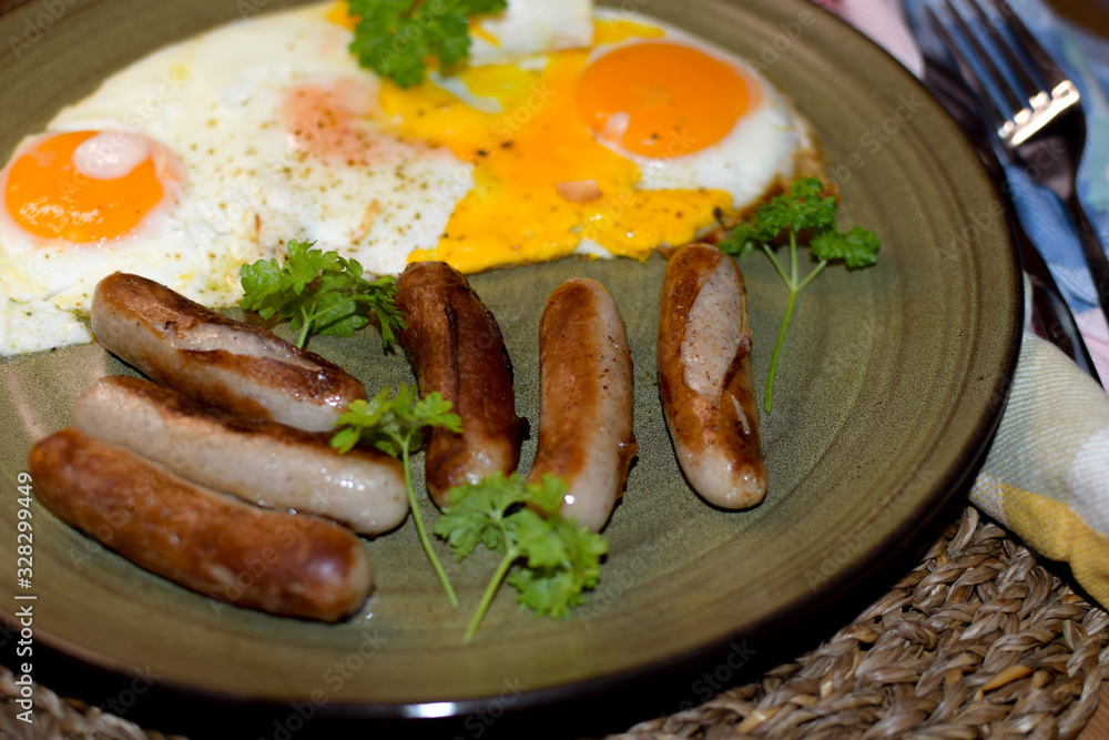 Fried Bavarian sausages and fried eggs are served on a ceramic plate. Fried Bavarian sausages and fried eggs are served on a ceramic plate.