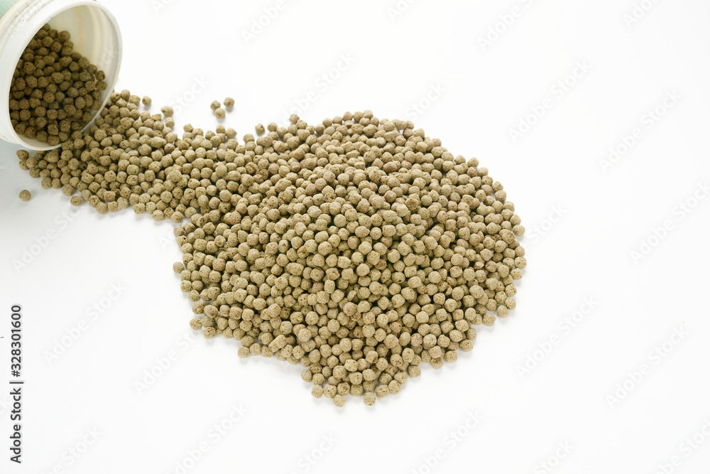 倒れた容器から出ている小粒で丸い金魚の餌 Stock Photo Adobe Stock