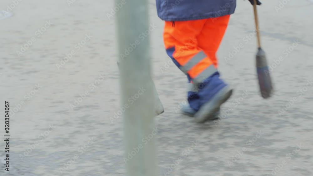 A male worker sweeps and cleans the street A male worker sweeps and cleans the street