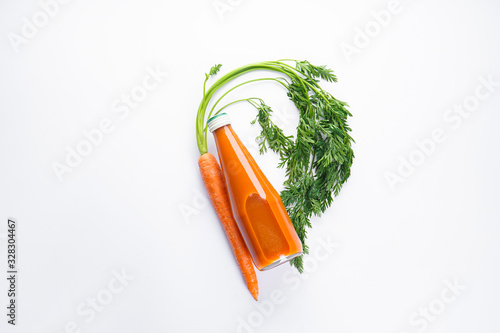 Flat composition with fresh carrot and carrot juice on a white background