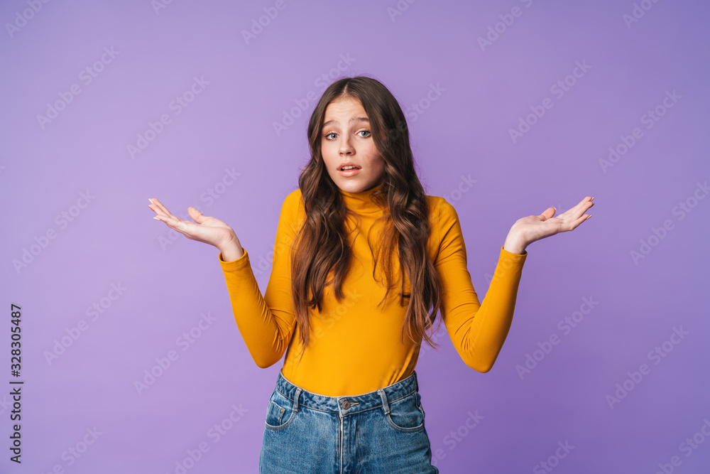Image of young beautiful woman hesitating and throwing up arms