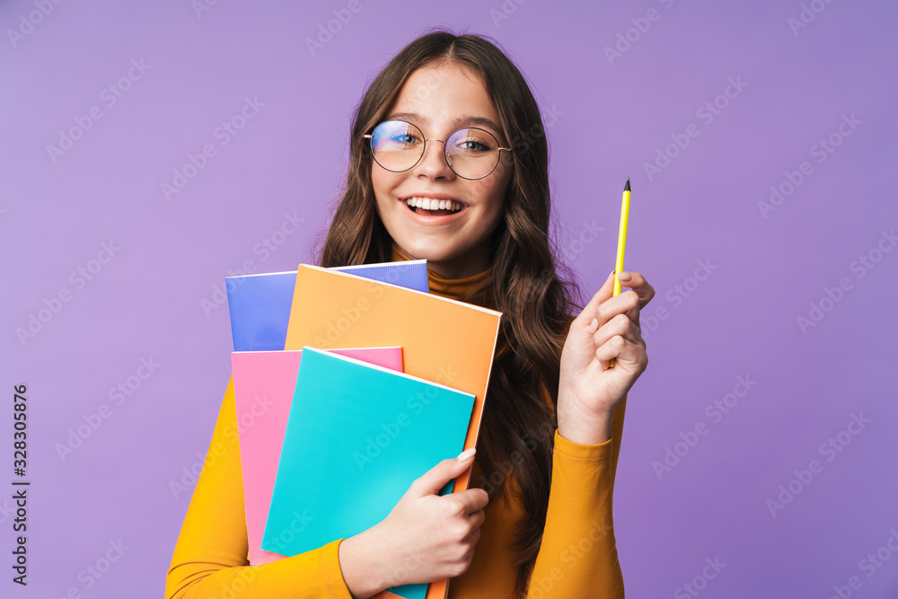 Image of young beautiful student girl smiling and holding exercise books