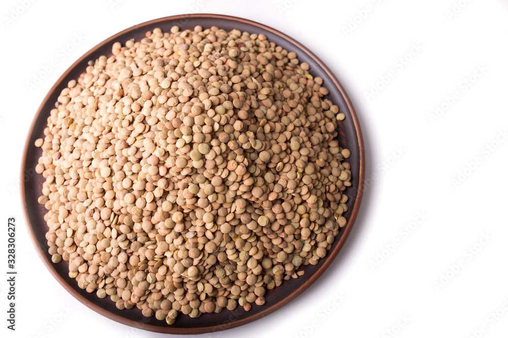Raw green lentils in a plate? on a white background. Raw green lentils in a plate? on a white background.