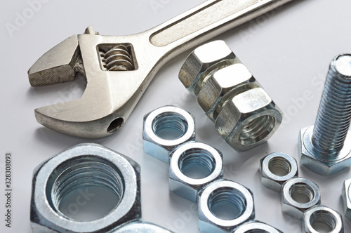 screw-nut of different sizes, bolts and adjustable spanner. White background. Concept.