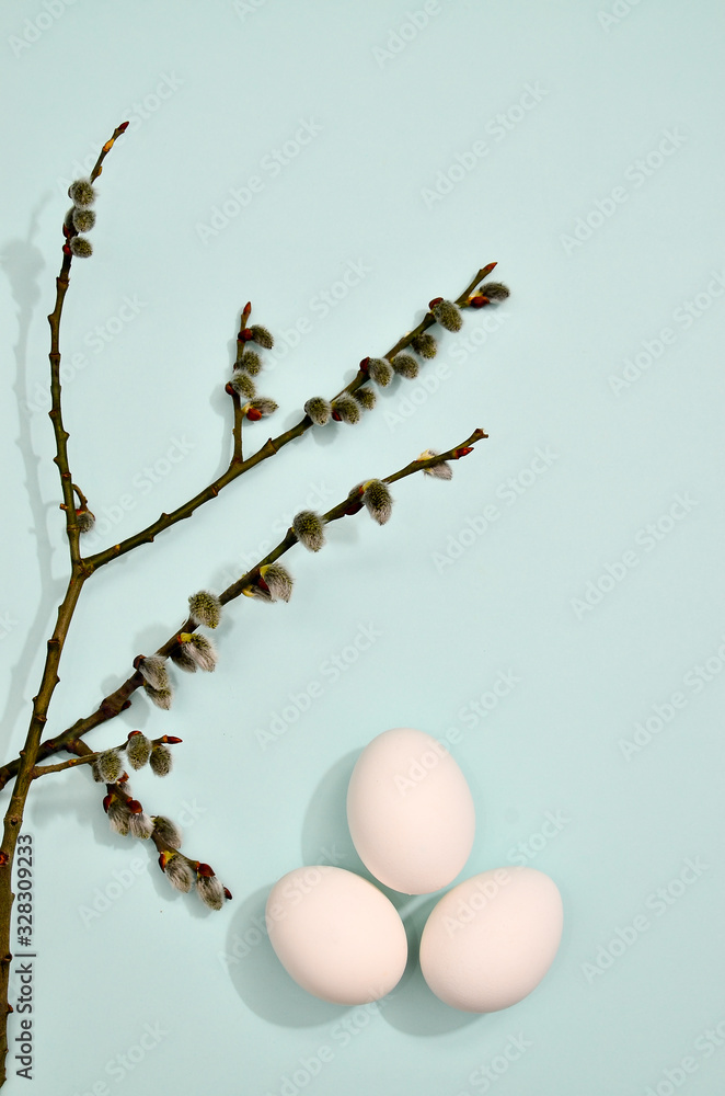 White eggs with willow branches pattern on vibrant pastel color background. Spring and Easter holiday concept with copy space.