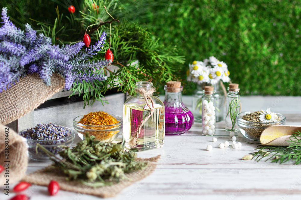 Variety of herbs and herbal mixtures as an alternative medicine concept on wooden table background over green grass.