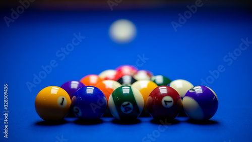 Colorful balls on a blue pool table. Set up and ready to play. Selective focus.