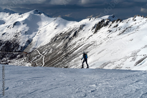 Skier going up the hill. Uphill skiing. Skinning. Alpine touring.