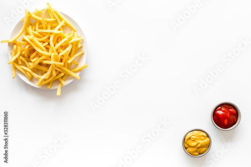 Fast food symbol. French fries on plate on white table top-down copy space