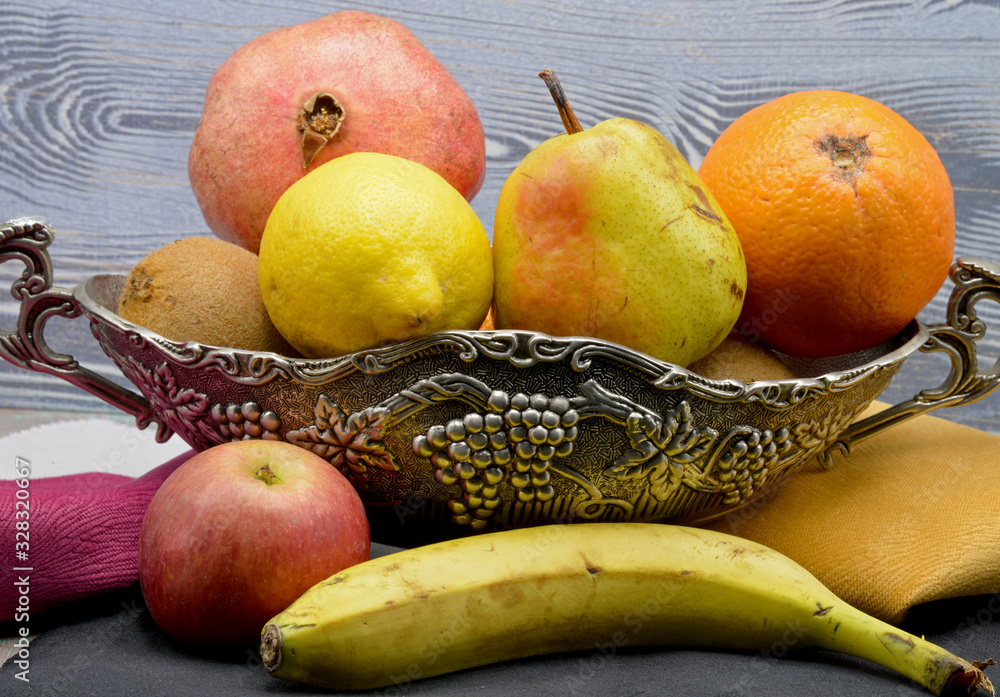 fresh fruits in a basket on wooden background