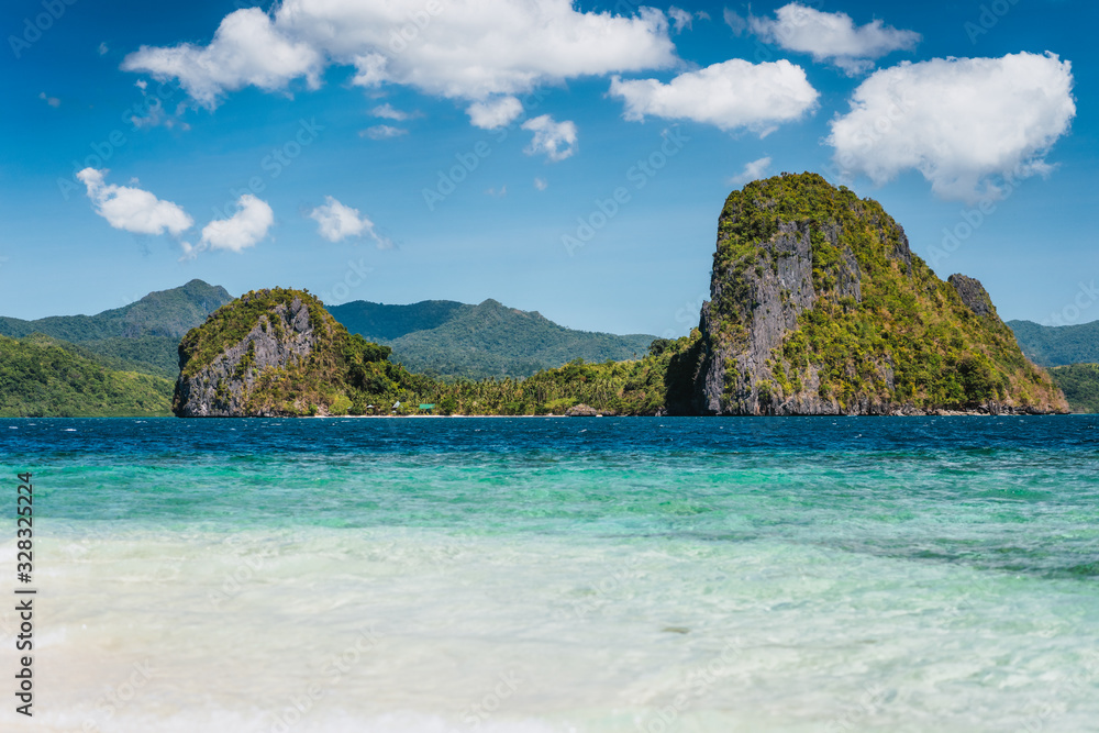 El Nido, Philippines. Crystal clear blue water lagoon and private Malapacao island in background