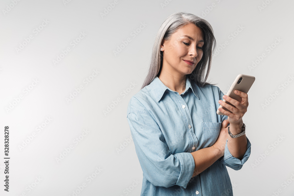 Image of adult mature woman with long white hair holding cellphone Image of adult mature woman with long white hair holding cellphone