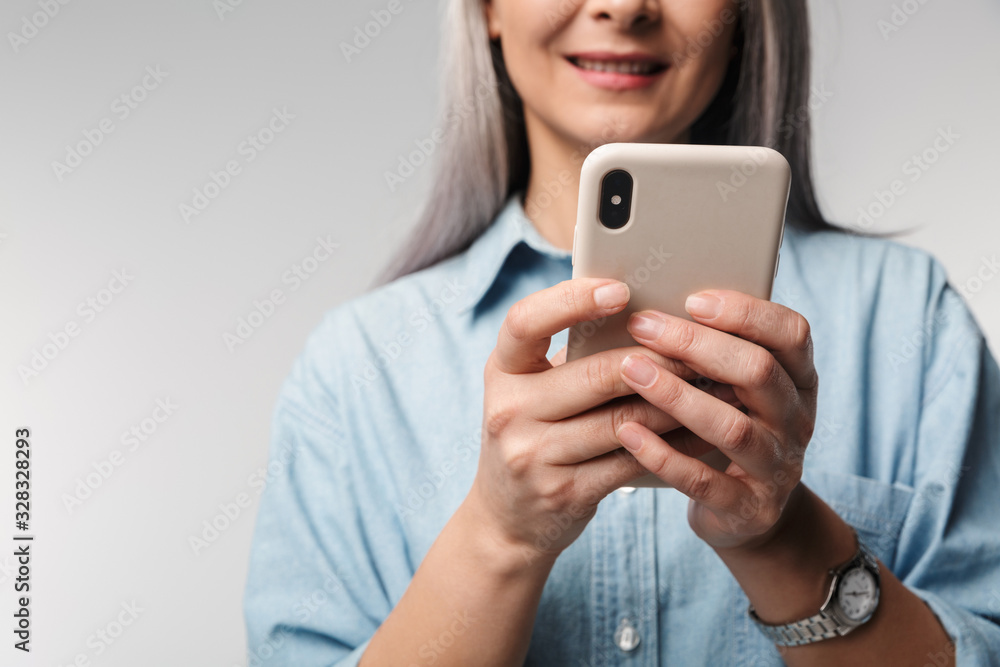Image of adult mature woman with long white hair holding cellphone Image of adult mature woman with long white hair holding cellphone