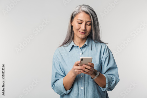 Obraz na plátně Image of adult mature woman with long white hair holding cellphone