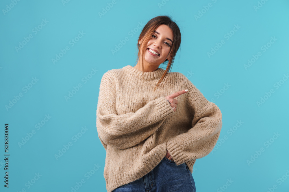 Image of happy caucasian woman smiling and pointing finger aside Image of happy caucasian woman smiling and pointing finger aside