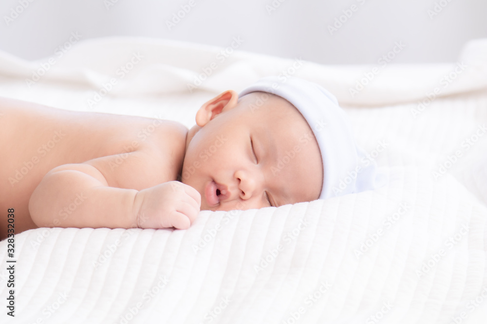 Adorable Asian newborn baby deeply sleeping smile Easter costume hat, tiny infant boy soft skin healthy sleep dream on white blanket on bed beautiful sun light, newborn baby health care concept Adorable Asian newborn baby deeply sleeping smile Easter costume hat, tiny infant boy soft skin healthy sleep dream on white blanket on bed beautiful sun light, newborn baby health care concept