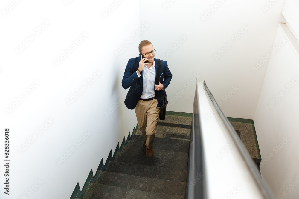 Businessman indoors walking by upstairs