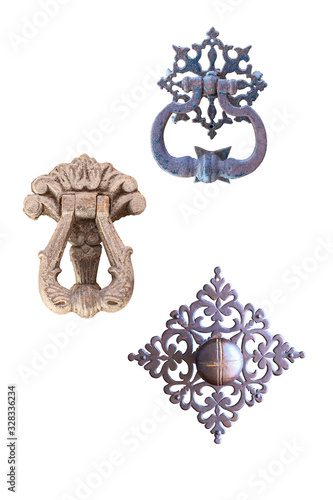 three old metal door handle with a beautiful metal ornament isolated on a white background