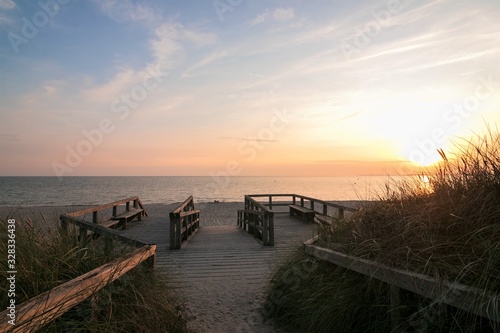 idyllic boardwalk to the fine sand beach at sunset