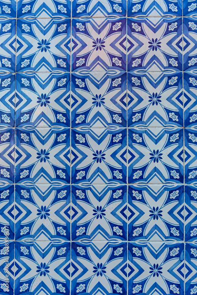 a fragment of the outer wall of a house in Lisbon decorated with ceramic tiles with a beautiful geometric pattern