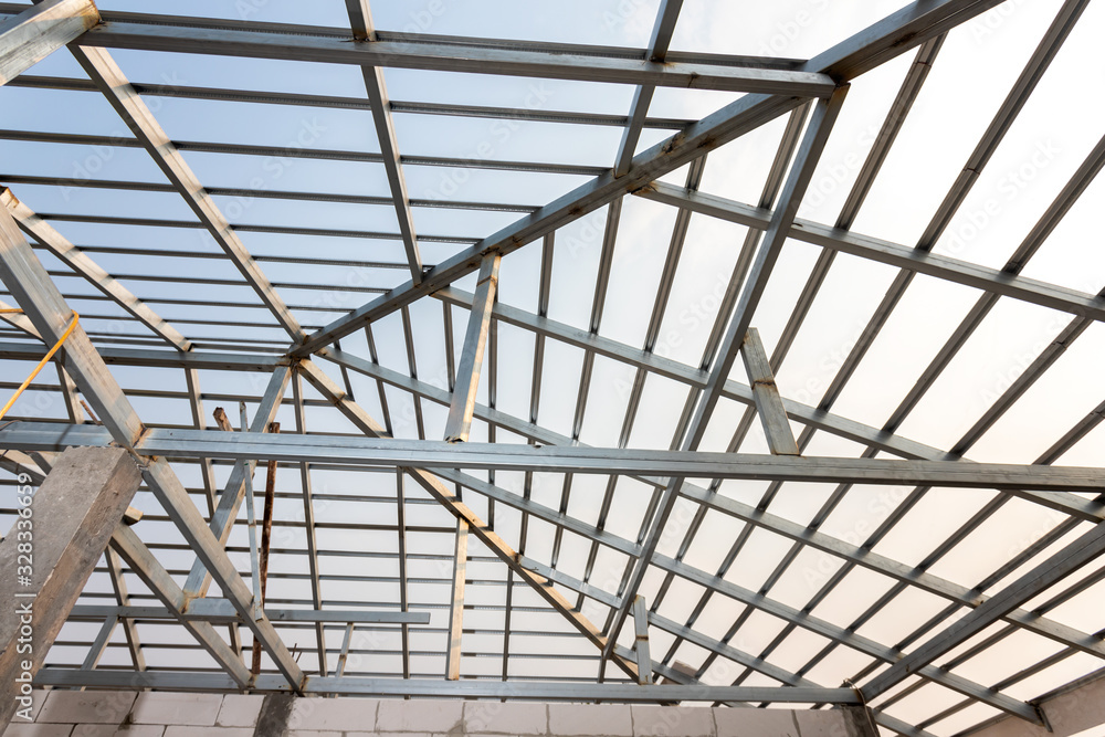 Structure of steel roof frame for home construction. Concept of residential building under construction.