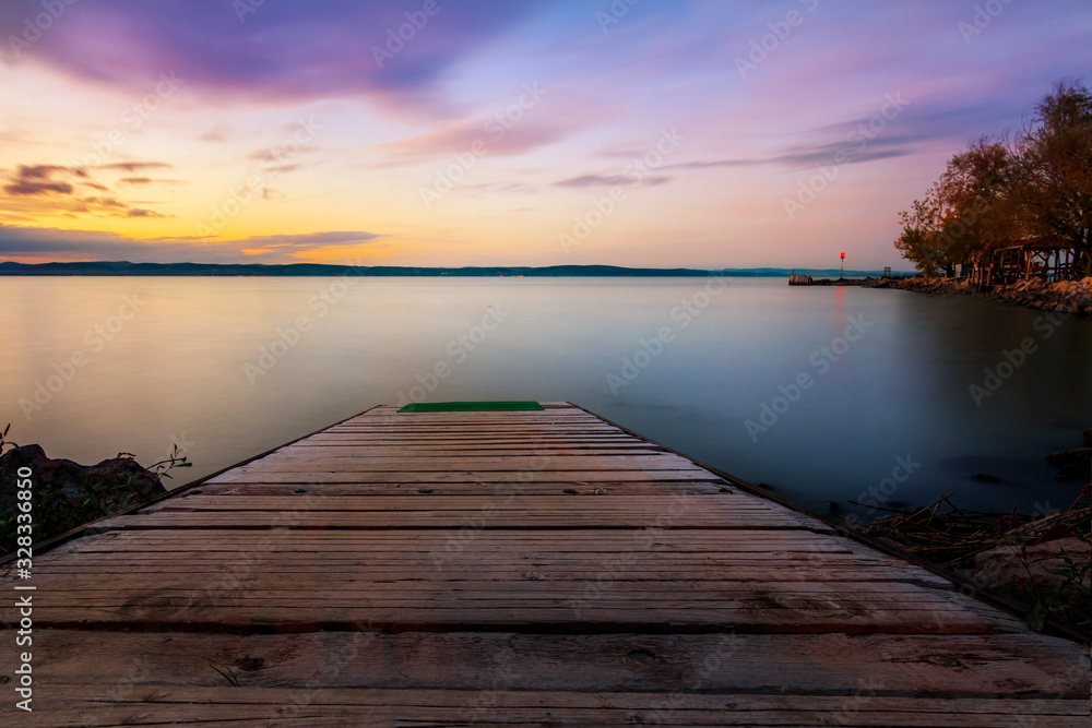 sunset on lake with a jetty in the water at Lake Balaton in Hungary,