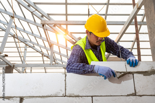 Photos bricklayer builder working with autoclaved aerated concrete blocks