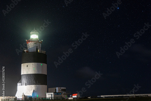 Hook Lighthouse at night with the stars above, beautiful landscape.