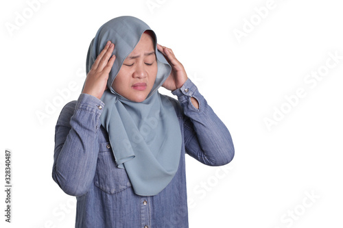 Portrait of Asian muslim lady wearing hijab hold her head in pain for having headache © airdone