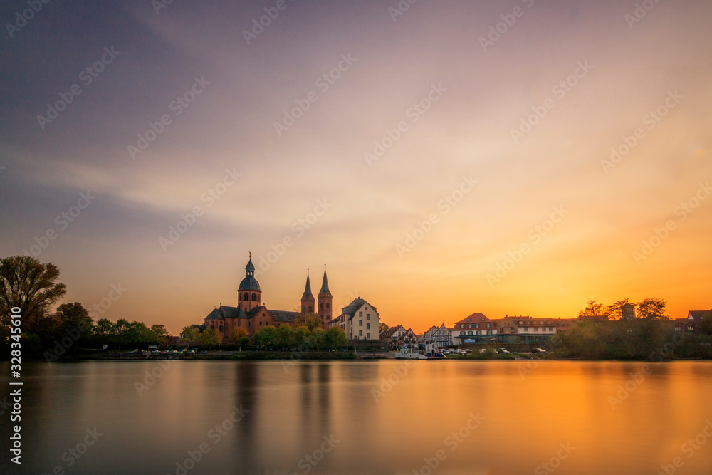 sunset over the city, beautiful sunset or sunrise over an old monastery in Seligenstadt Hessen Germany.  a nice long exposure over a liquid at sunset