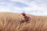 Young woman exercise in dry grass  after joggin in the nature