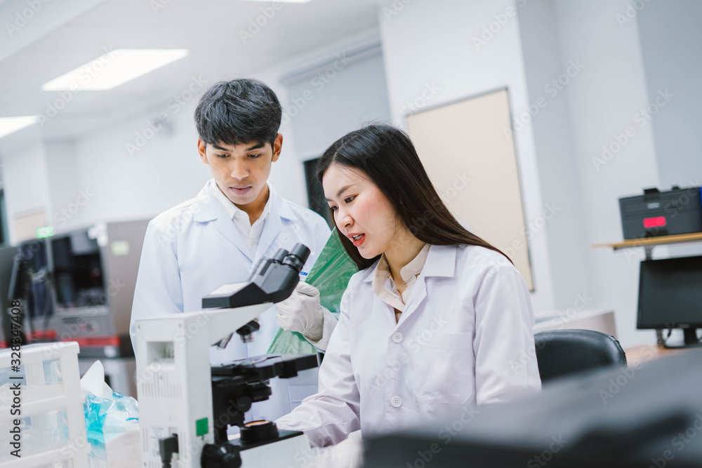 Two medical scientist consult at microscopic analysis in medical laboratory Two medical scientist consult at microscopic analysis in medical laboratory