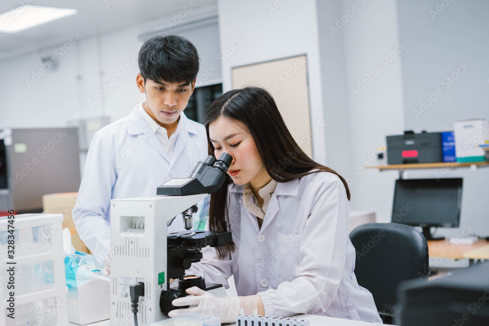 Two medical scientist consult at microscopic analysis in medical laboratory Two medical scientist consult at microscopic analysis in medical laboratory