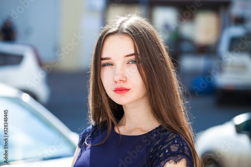 Close up portrait of a young beautiful brunette girl in blue dress