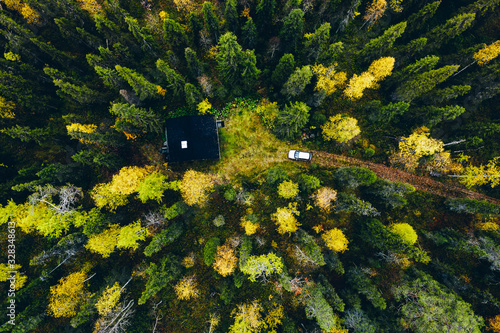 Aerial top view of log cabin or cottage with country road in spring forest in Finland